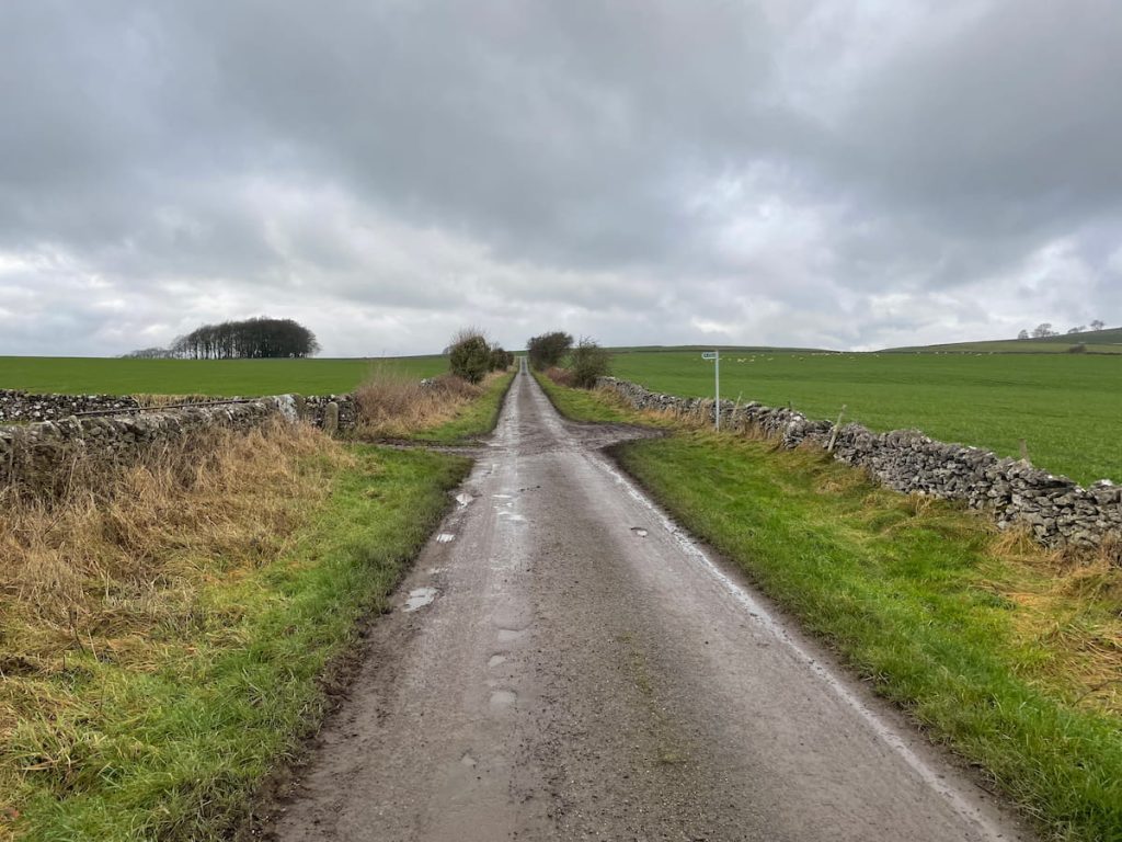 road leading to a stile and gate on the left
