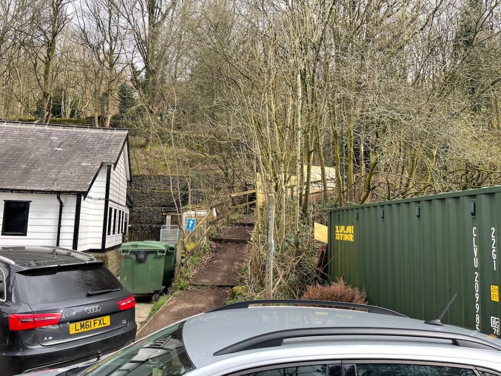 footpath marked with a blue arrow that leads uphill behind cafe